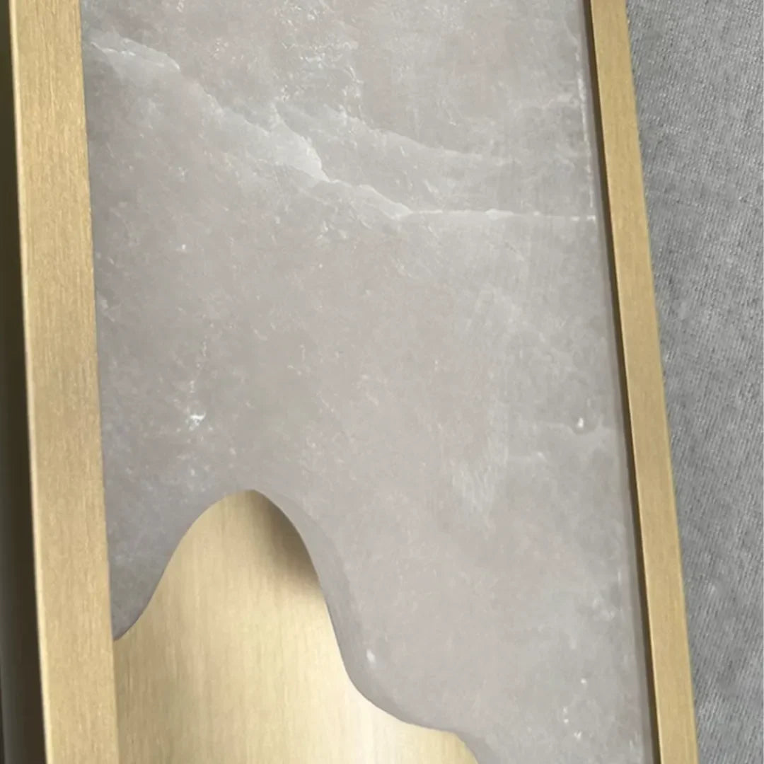 Niva marble stone panel detail, natural veining visible through lit wall sconce