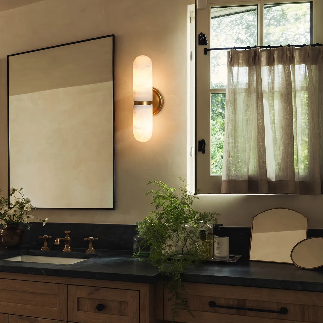 Niva two-light marble wall sconce installed beside a bathroom mirror as vanity lighting