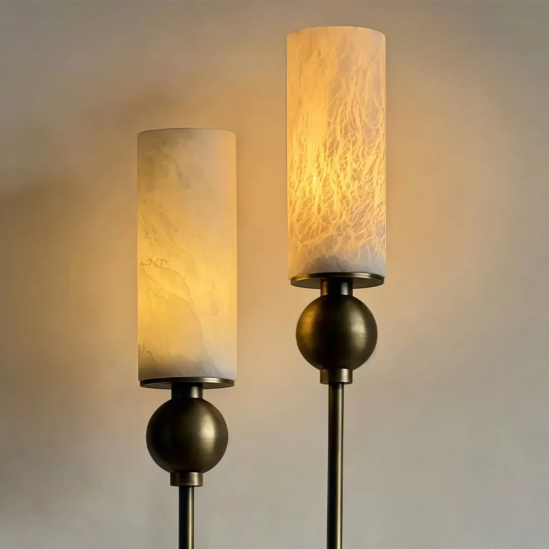 Close-up of Niva wall sconce showing brass arm detail and white marble shade texture