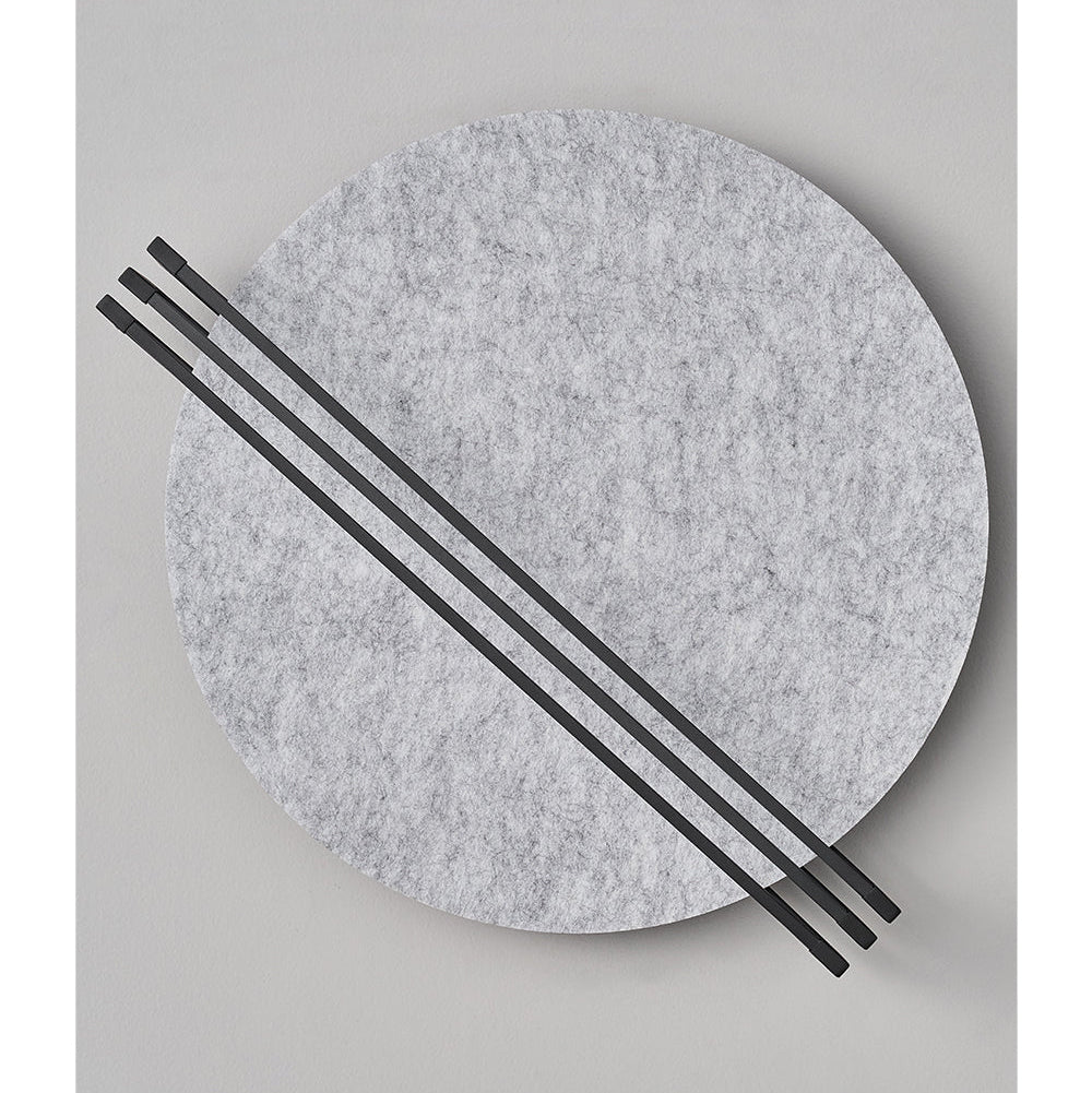 Vantara wall sconce in grey felt with cool white LED light, styled in a minimalist reading corner
