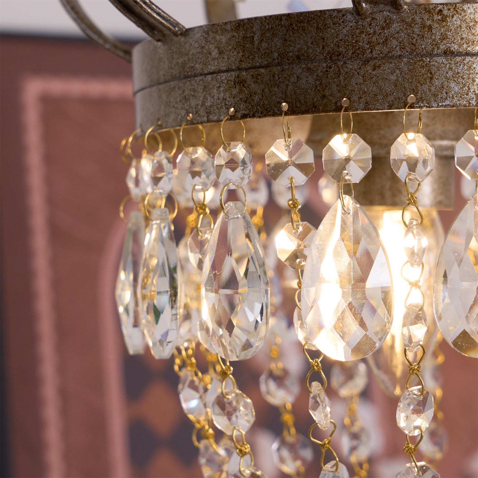 Vantara chandelier in antique gold above a round dining table, evening setting