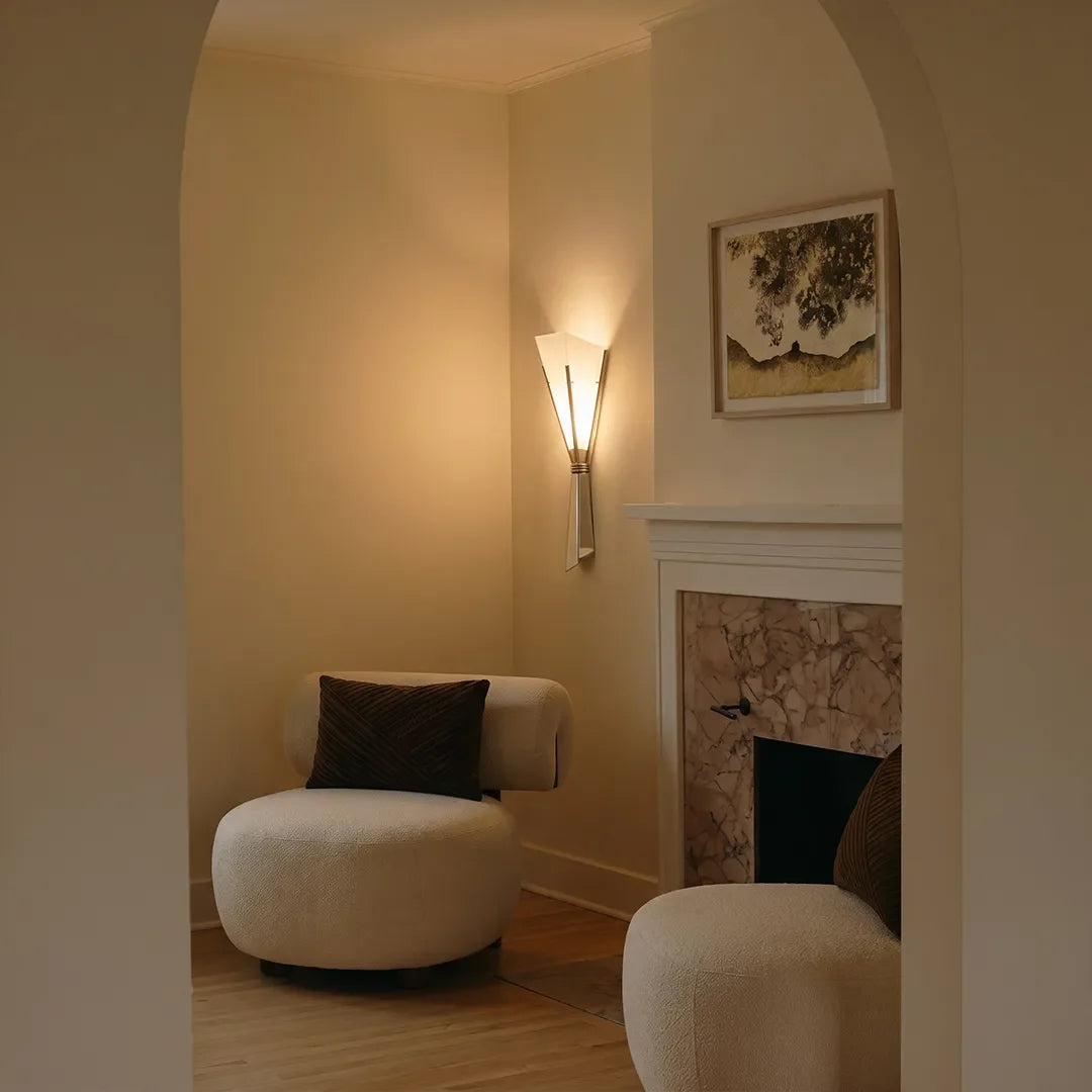 Niva marble wall sconce beside a fireplace in a reading nook setting