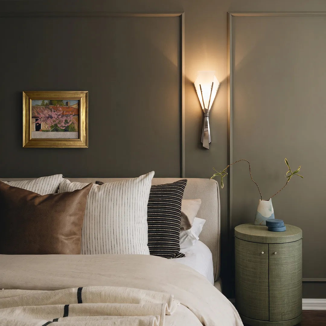 Niva marble wall sconce in a modern bedroom, illuminated warm white glow