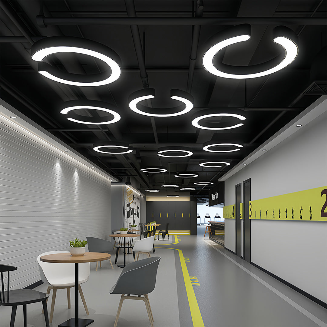 Aureon geometric pendant lights installed in an office corridor with warm yellow accent walls