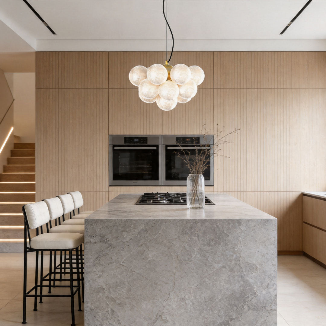 Auréline glass globe chandelier installed above a kitchen island, modern interior