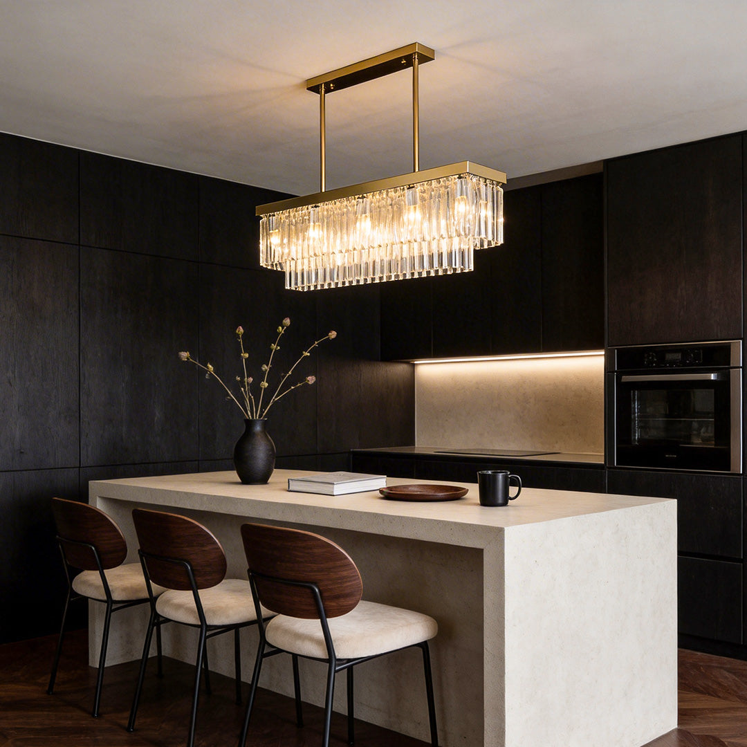 Gold rectangular crystal chandelier above a kitchen island in a contemporary interior