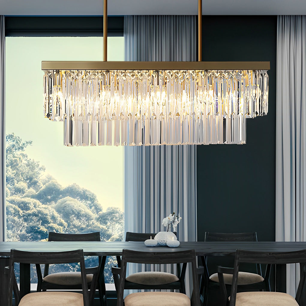 Gold rectangular crystal chandelier above a dining table in a sleek, modern interior