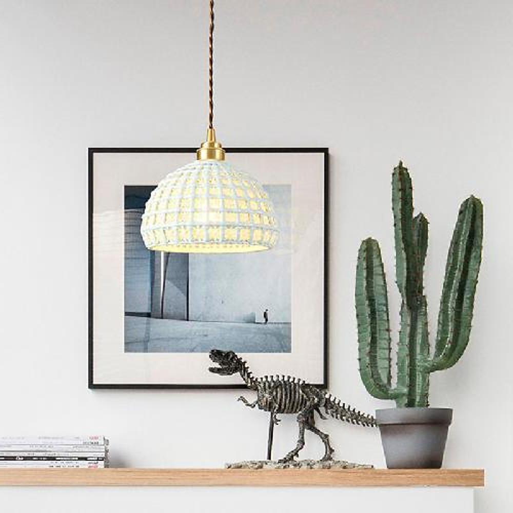Aureon ceramic dome pendant light in white with brass copper frame, hanging in a modern dining room