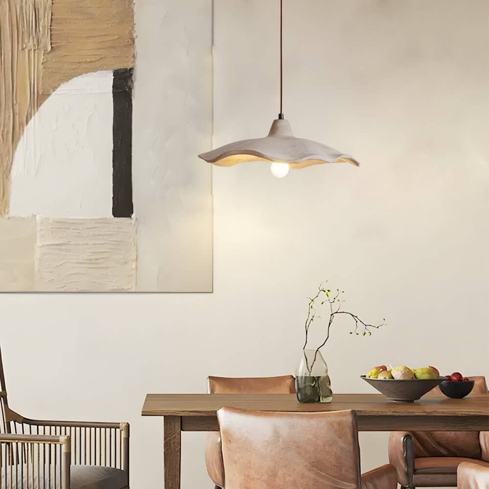 Aureon cement wave pendant light in pottery yellow above a modern dining table