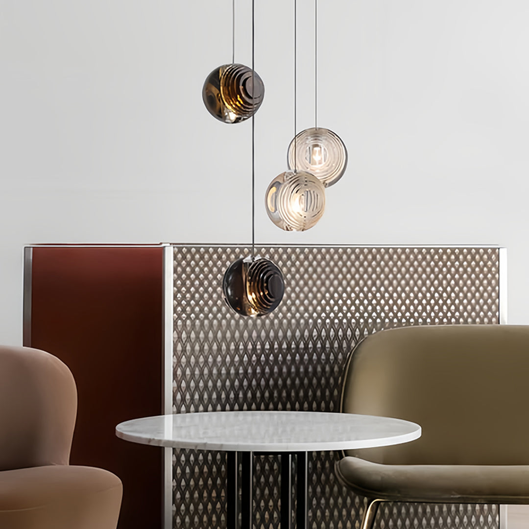 Aureon smoked glass pendant lights above a round dining table in a contemporary lounge