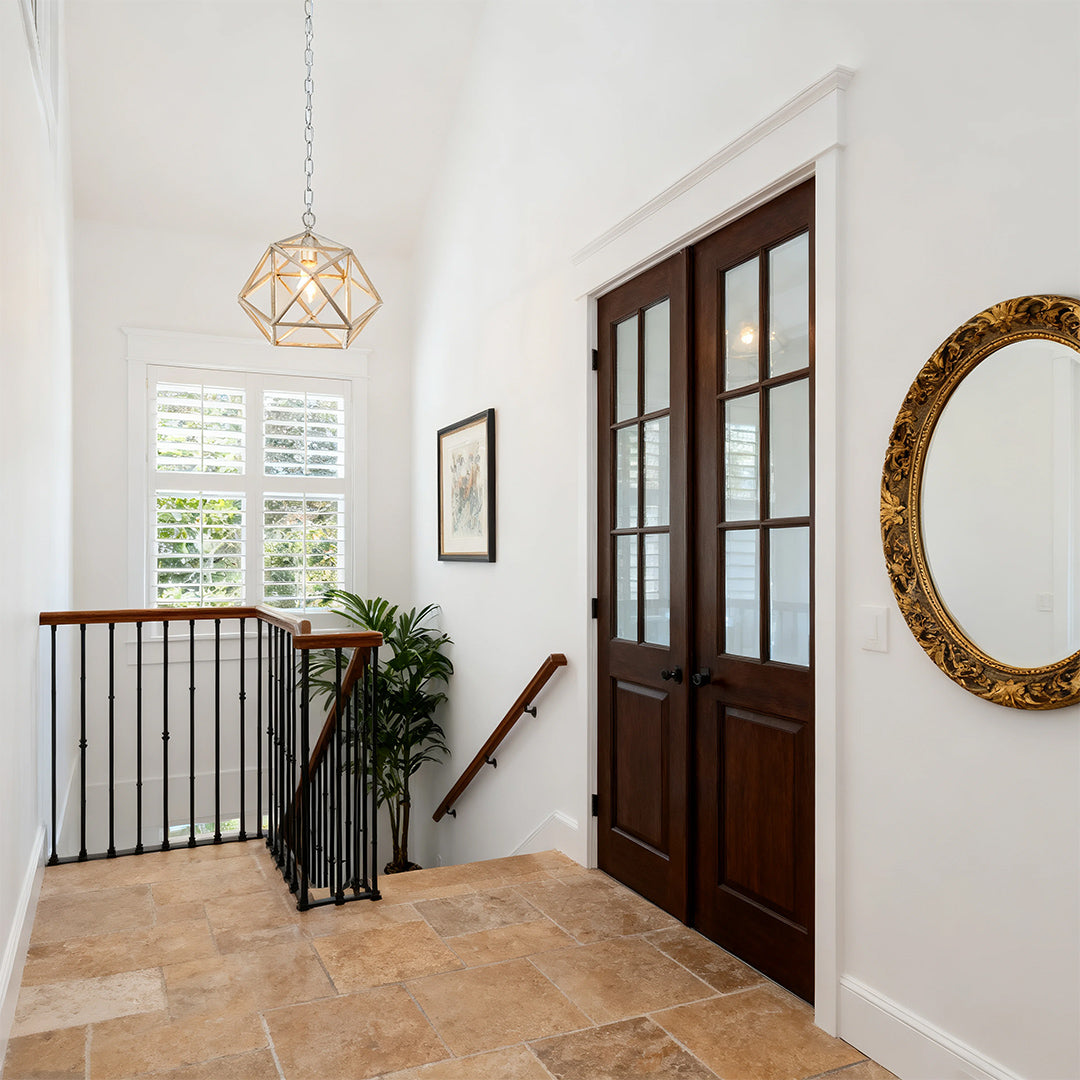 Aureon gold geometric pendant light in a bright minimalist hallway with French doors