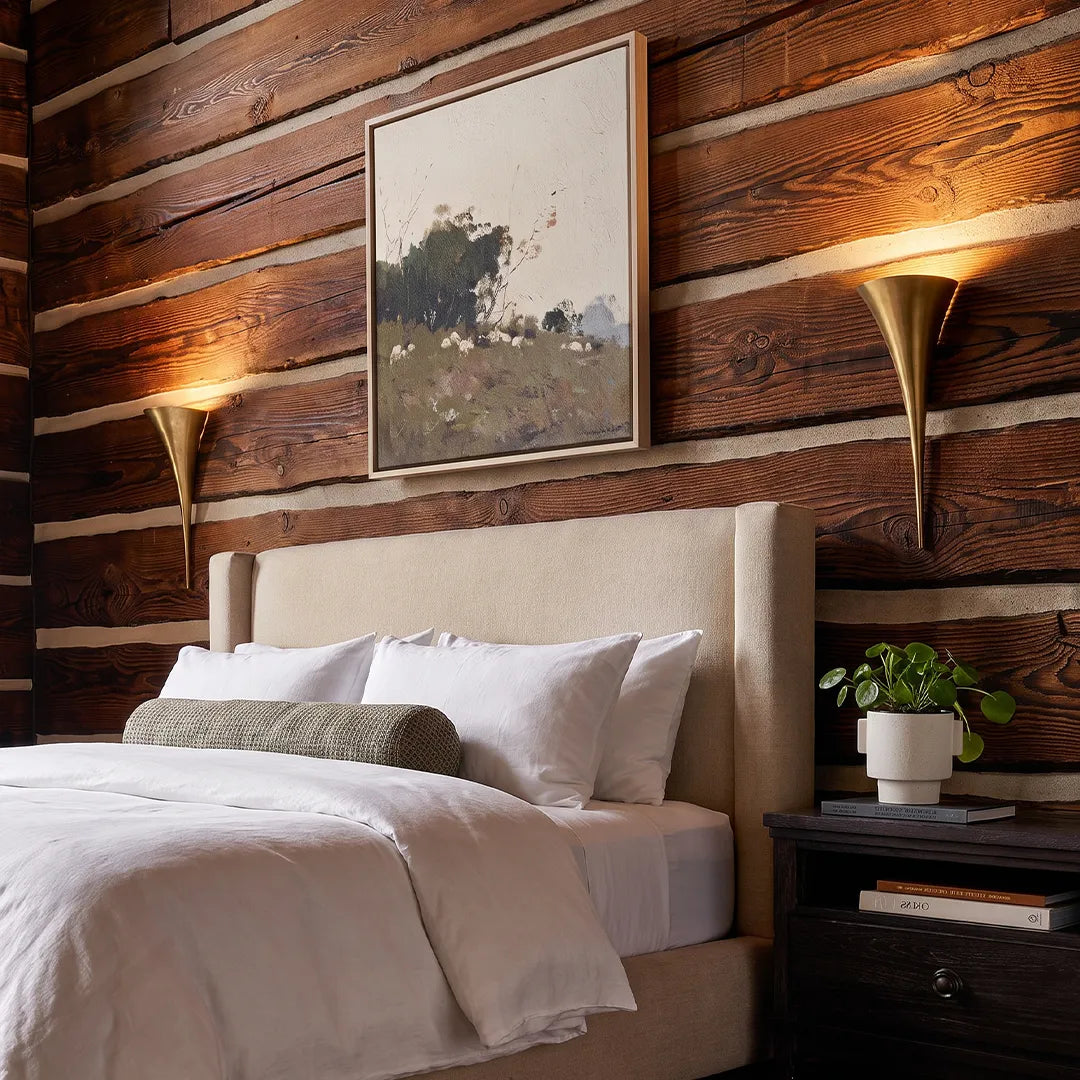 Brass wall sconce mounted on a wood-panelled wall in a modern bedroom interior