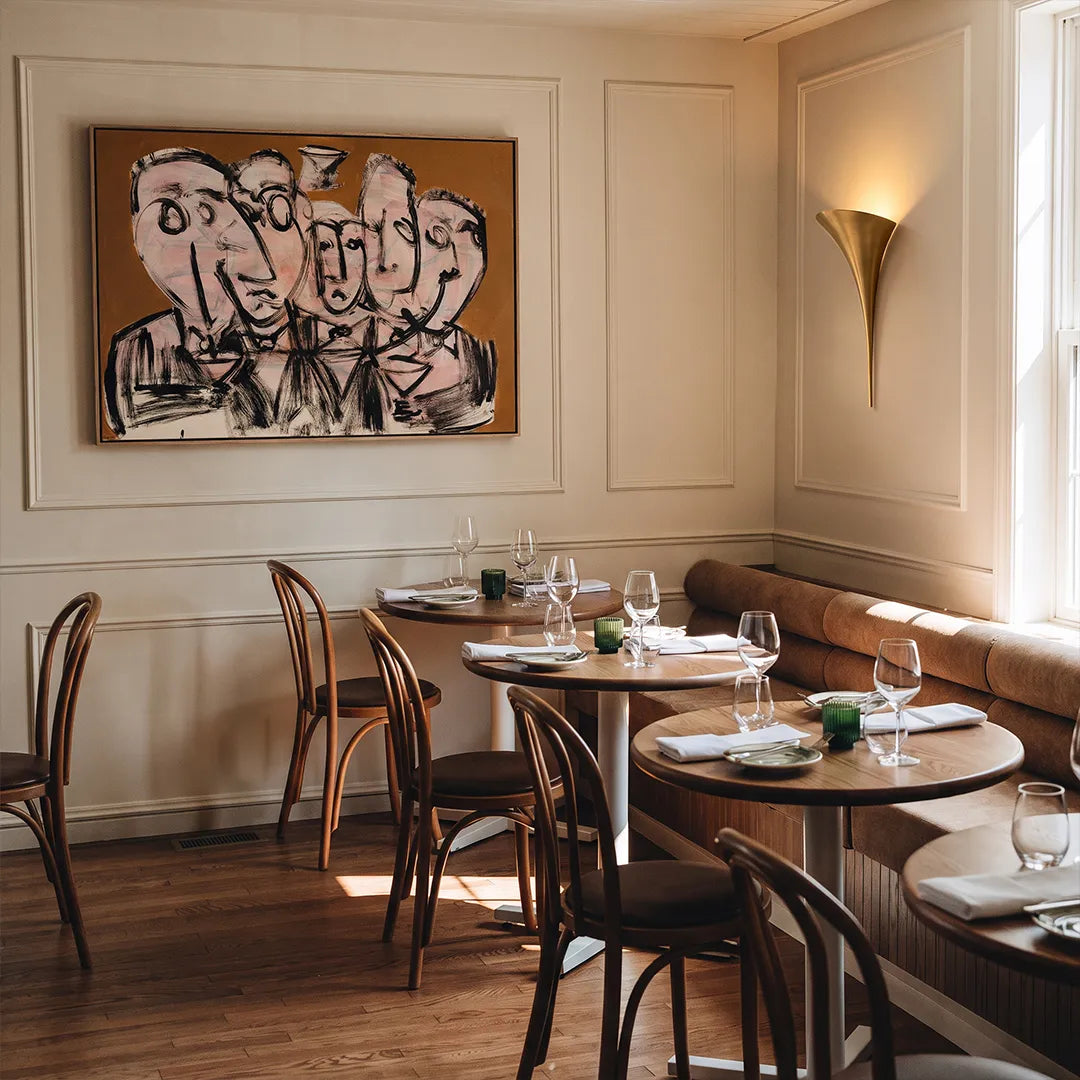 Large brass wall sconce providing indirect uplighting in a contemporary dining room