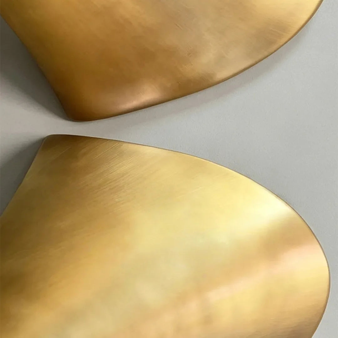 Detail shot of the metallic finish on a modern brass wall sconce