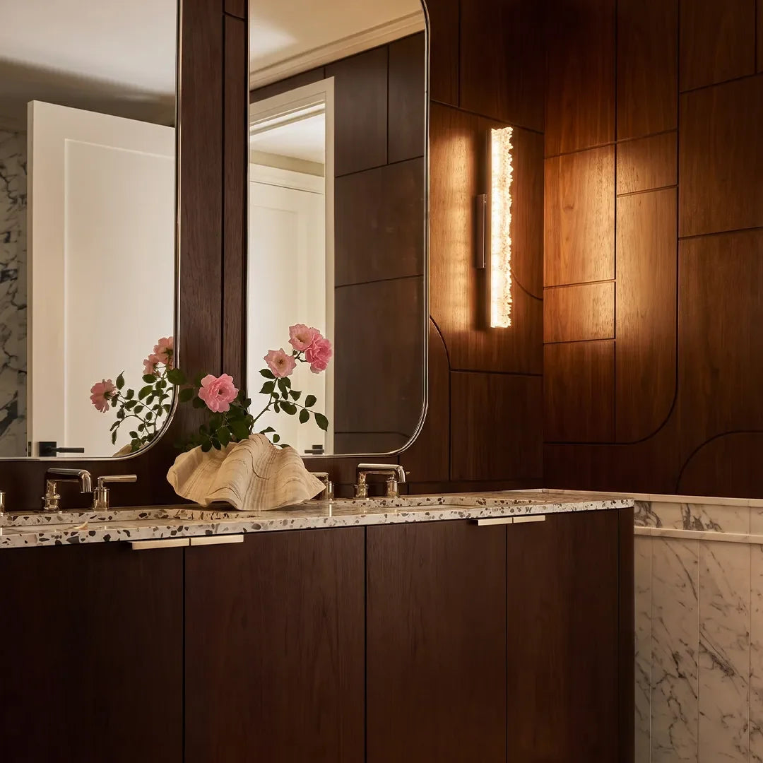 Niva crystal wall sconce mounted above a dark wood bathroom vanity