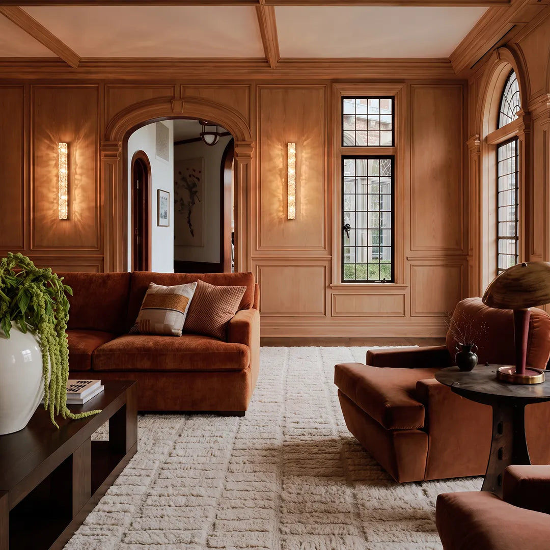 Niva crystal wall lights installed in a set across a paneled living room feature wall