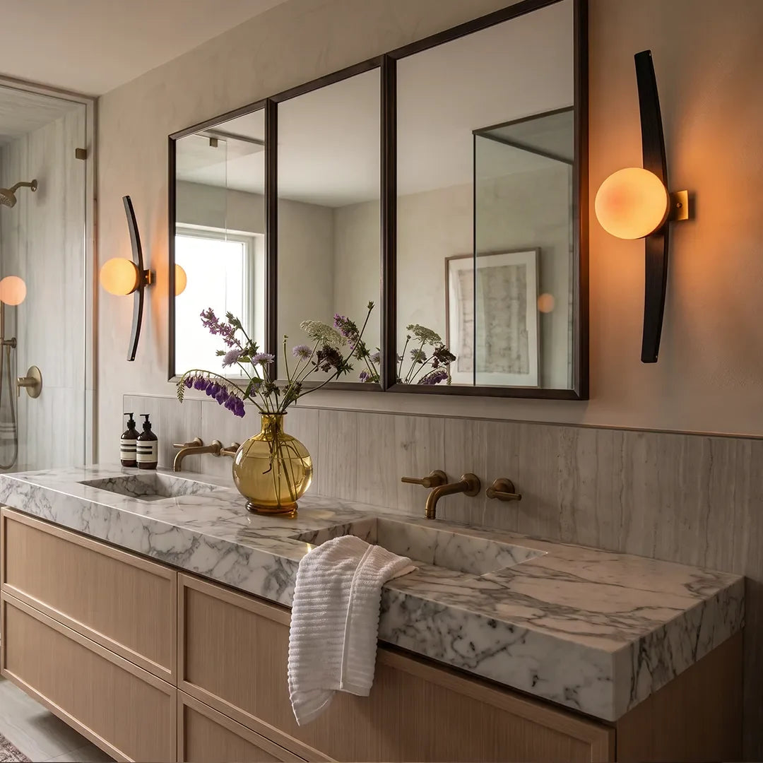Pair of Niva curved wood and glass wall sconces mounted either side of a bathroom vanity mirror