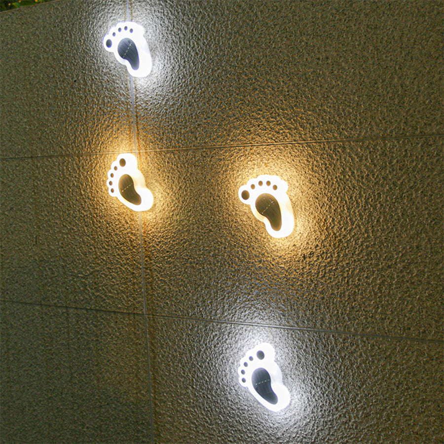 Multiple Solvara solar footprint LED path lights installed along a garden pathway at dusk