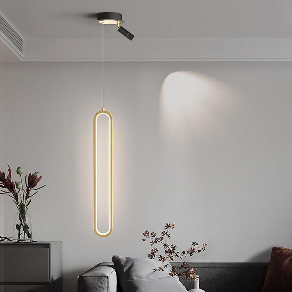 Aureon rectangular pendant light in gold finish, lit in a contemporary dining room setting