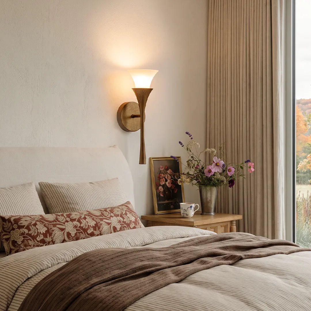 Niva single-head brass wall sconce in a neutral modern bedroom