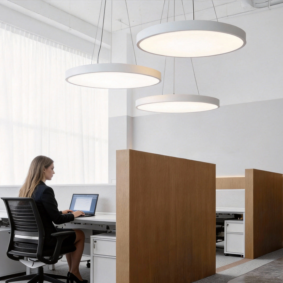 Round LED pendant lights over a modern office workstation area