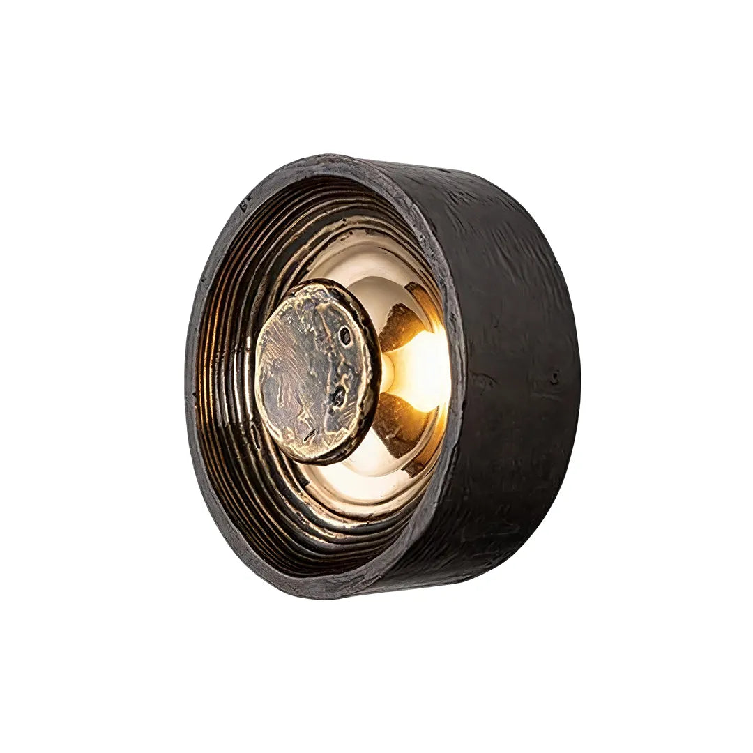 Close-up of Niva wall sconce showing layered recessed ring detail and raised circular centre