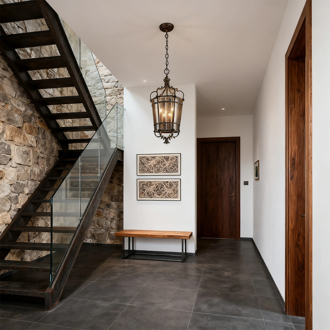 Antique bronze cage lantern pendant light mounted in a stone wall entryway
