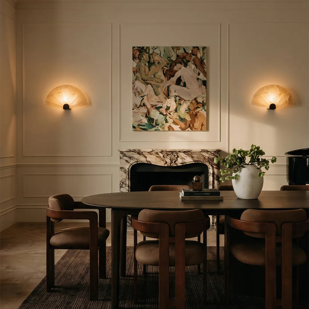 Pair of scalloped marble wall sconces in a dining room, symmetrically installed on a feature wall