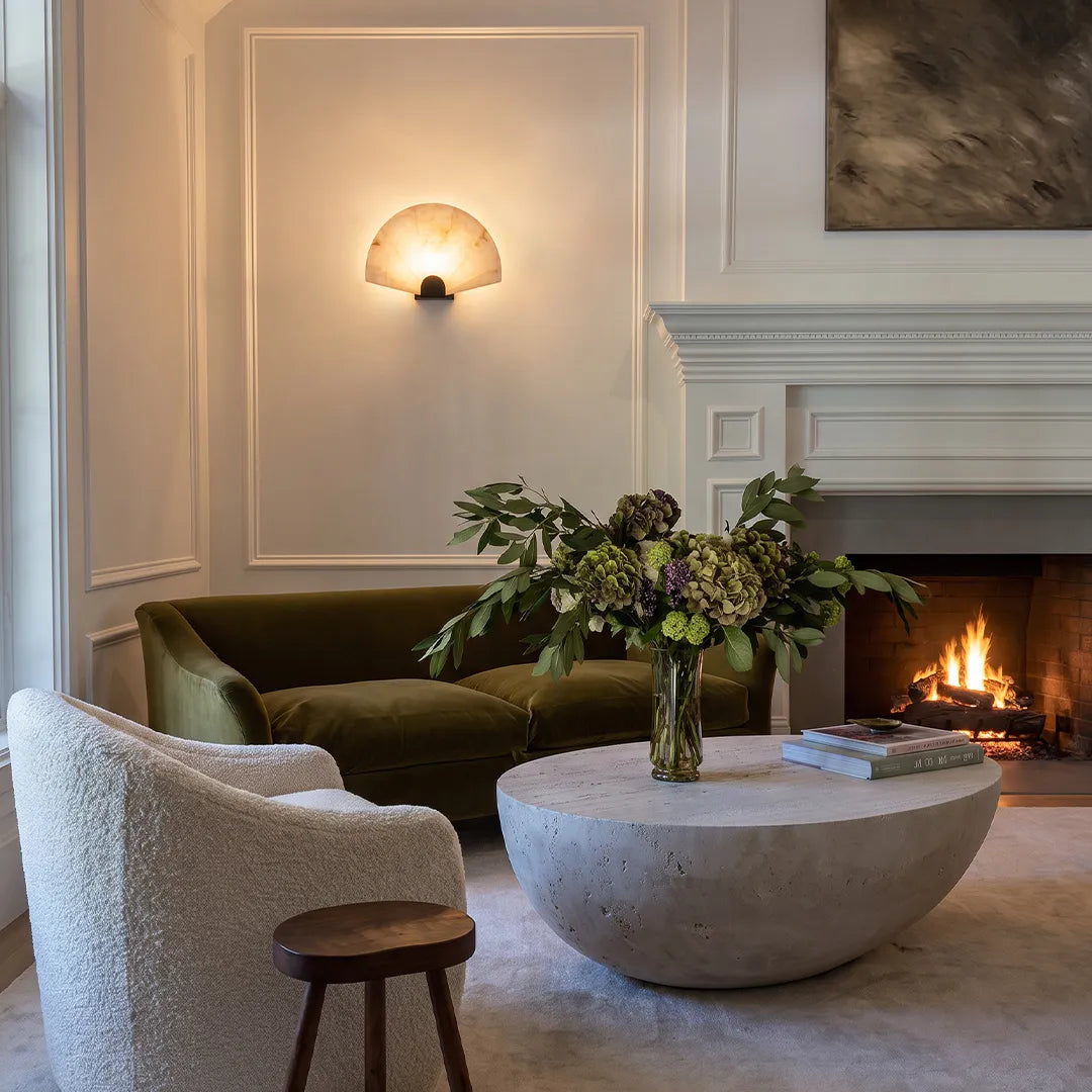 Niva marble wall sconce mounted above a fireplace in a modern living room interior