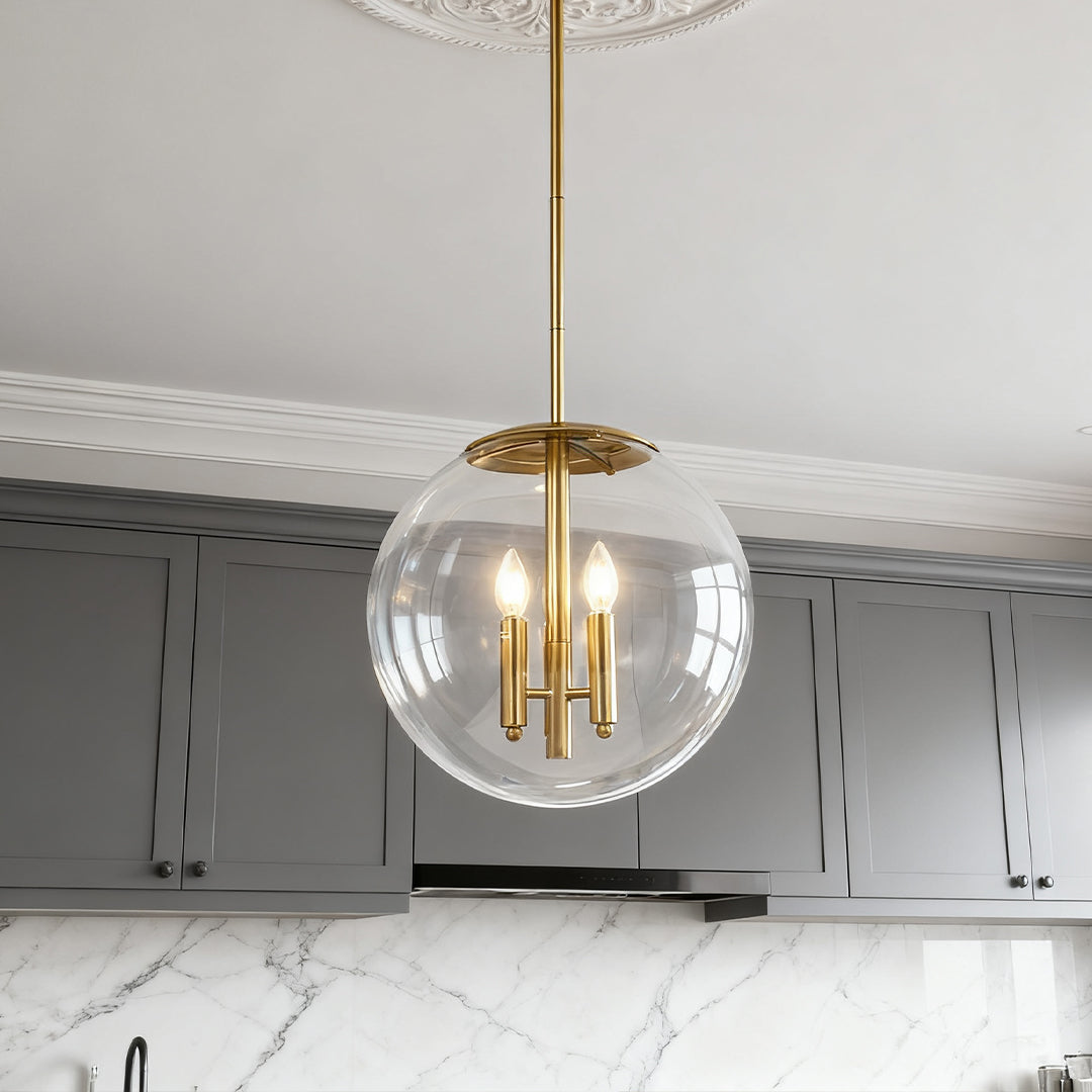 Single brass rod clear globe pendant light in a modern gray kitchen interior