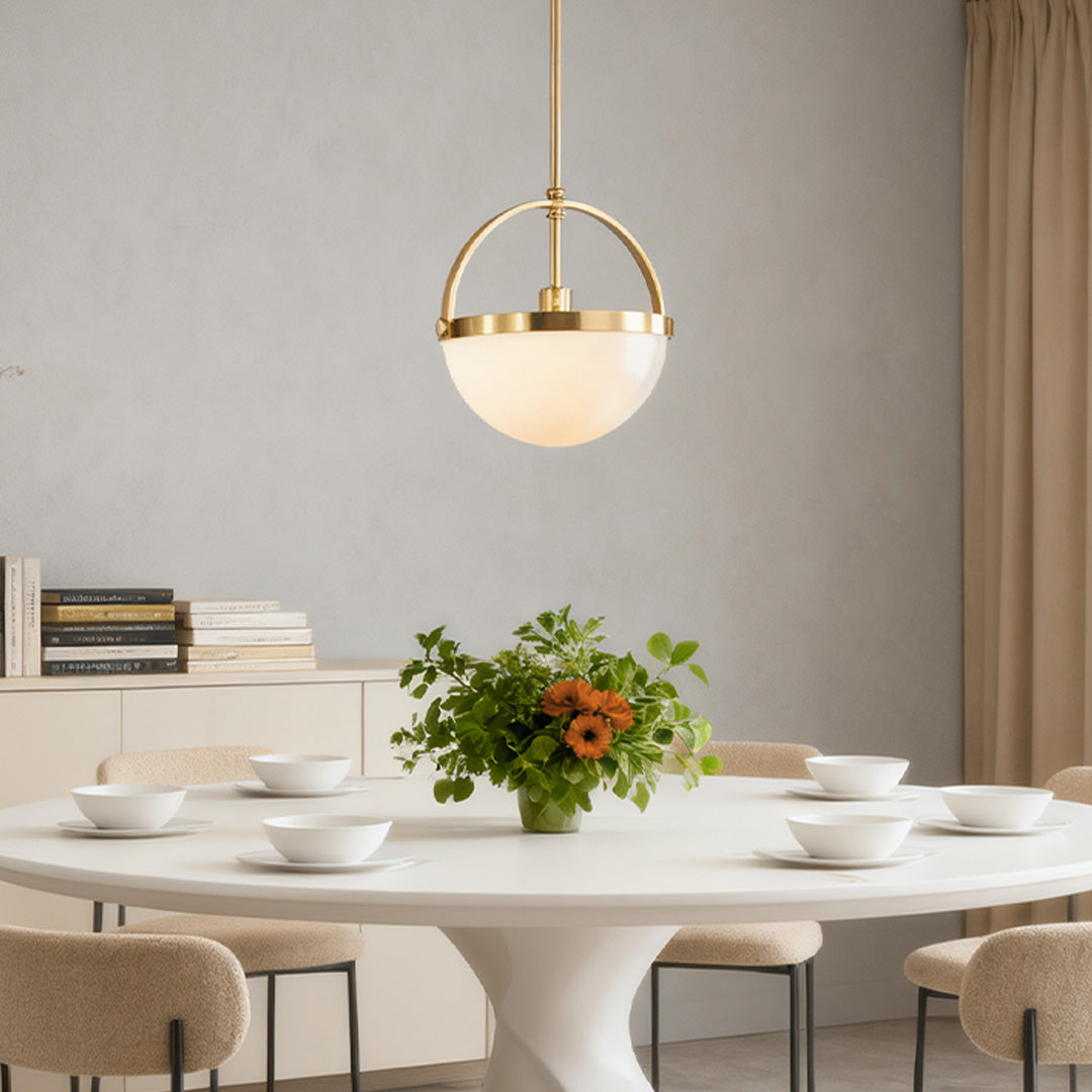Single opal frosted glass pendant light with gold copper fitting in a minimalist airy space
