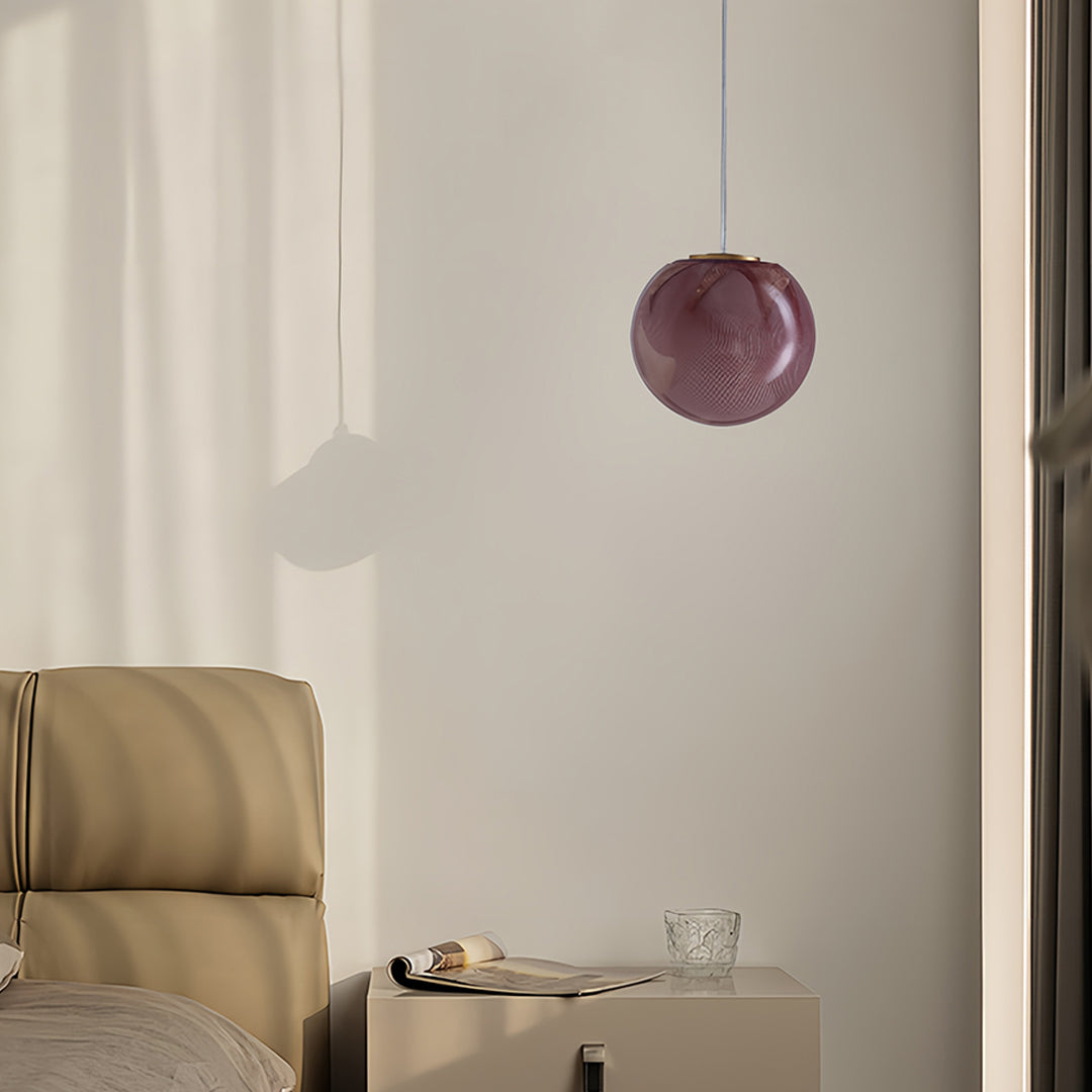 Textured amber glass globe pendant light in a bedroom interior
