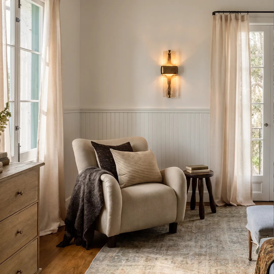 Niva resin wall sconce in a reading nook, soft warm LED light, black finish