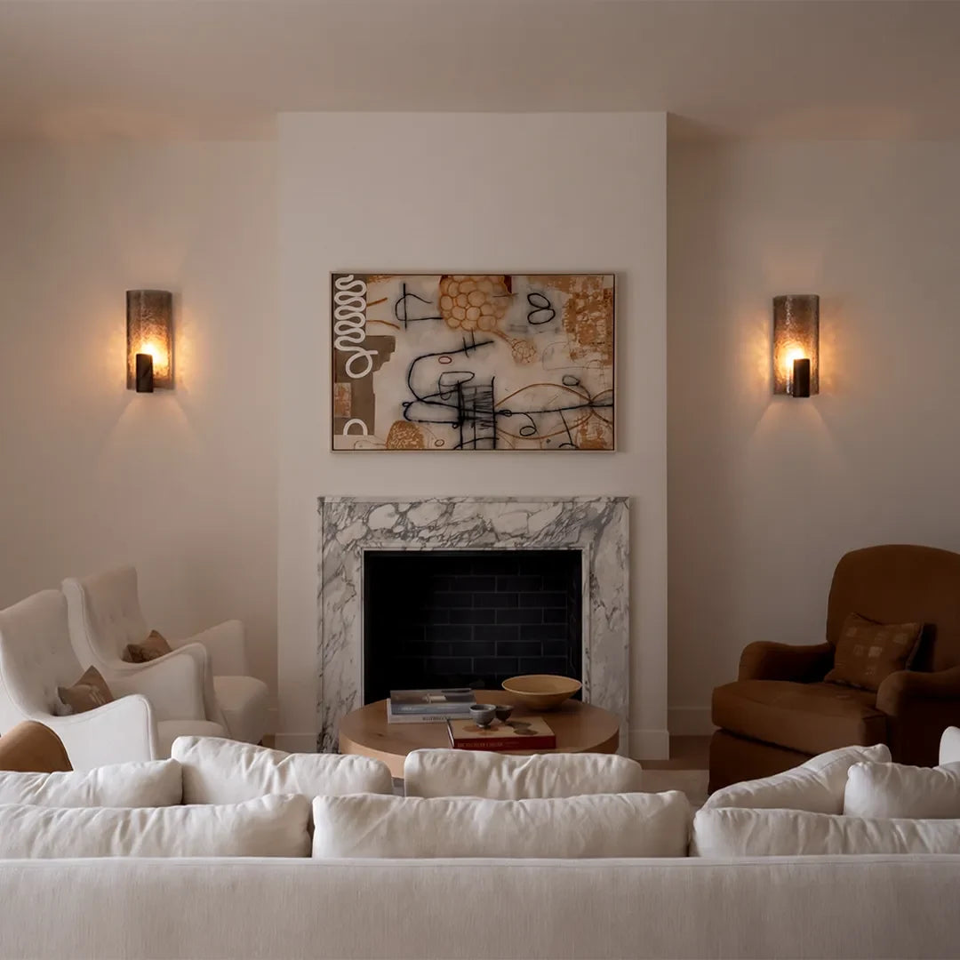 Pair of Niva glass wall sconces mounted either side of a fireplace in a contemporary living room