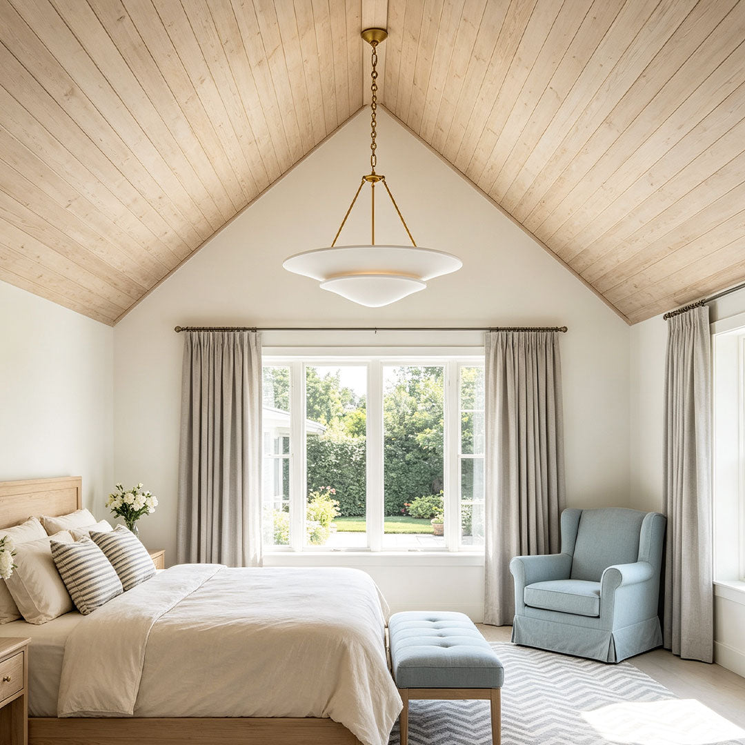 White plaster chandelier providing warm ambient light above a bedroom