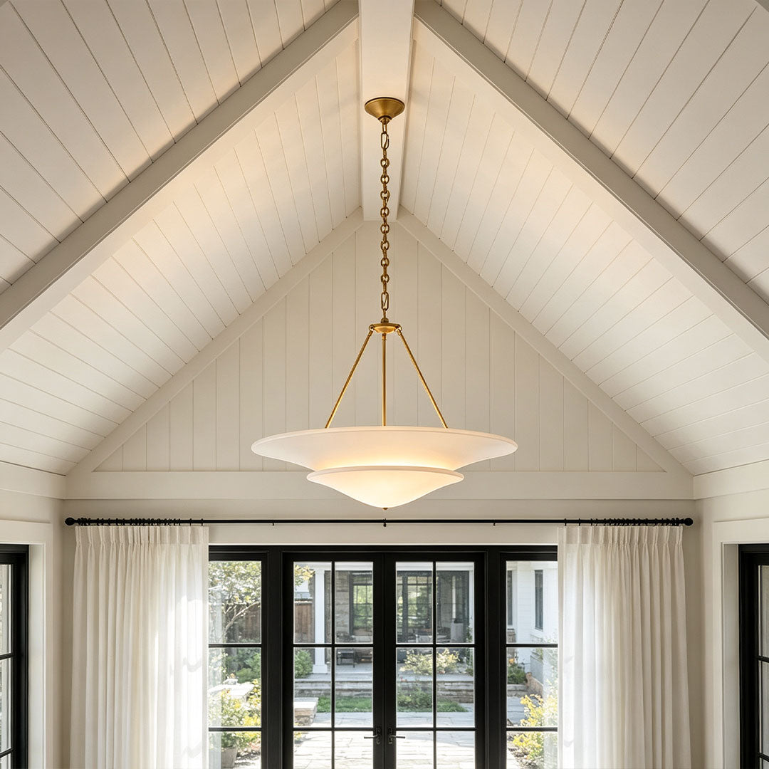 White plaster chandelier hung in a vaulted living room with high ceilings
